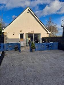 uma casa com uma cerca azul em frente em Fearmore view em Kildare