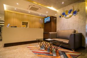 a waiting room with a couch and a table at Symphony Inn in Vellore