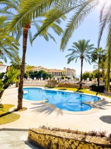 una piscina con palmeras en un resort en Ocean Mascarat, en Altea