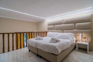 a bedroom with a large bed with two teddy bears on it at Correnti Boutique Hotel Gold in Sanremo