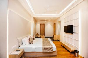 a hotel room with a bed and a flat screen tv at Hotel Euphoria Green in Amritsar