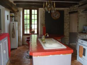 a kitchen with a sink and a red counter top at La maison d'Agnes en Haute Bourgogne in Jully