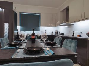 a table with a bottle of wine and wine glasses at A&G Luxury House in Porto Heli