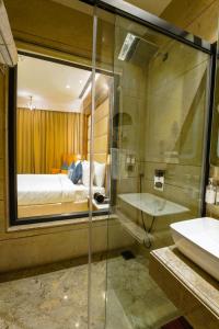 a bathroom with a shower and a bed and a sink at Regenta Place Mohali in Mohali
