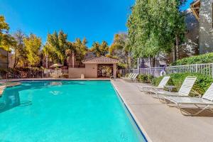 a swimming pool with lounge chairs and a house at Antique Retreat in Scottsdale