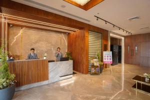 two men standing at a reception desk in a lobby at Regenta Place Chandigarh Mohali in Mohali