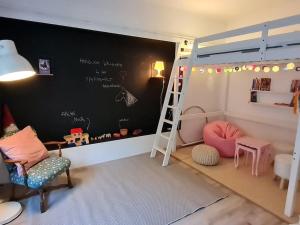 een kamer met een stapelbed en een schoolbord bij Cosy Family Apartment in Reichenau