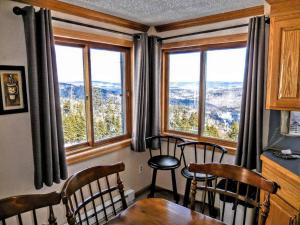 a dining room with a table and chairs and windows at ML246 Spacious Condo Mtn & Lake views fireplace in Snowshoe