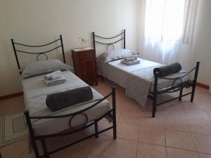 dwa łóżka w pokoju z dwoma krzesłami w obiekcie Sole dei Colli w mieście Vo Euganeo