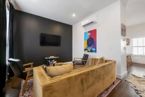 a living room with a couch and a tv on a wall at The Bourdain in Bentonville