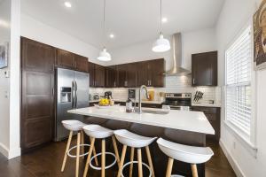 a kitchen with a large island with bar stools at The Bourdain in Bentonville