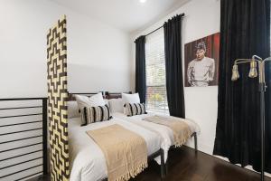 a bedroom with a large bed with black and white pillows at The Bourdain in Bentonville