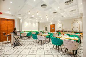a dining room with green chairs and tables at Hotel Euphoria Green in Amritsar