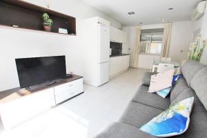 ein Wohnzimmer mit einem Sofa und einem Flachbild-TV in der Unterkunft Apartamento 10 Marjal Playa Centro de Guardamar in Guardamar del Segura