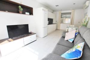 a living room with a couch and a flat screen tv at Apartamento 10 Marjal Playa Centro de Guardamar in Guardamar del Segura