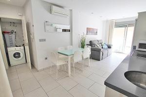 eine Küche und ein Wohnzimmer mit einem Tisch und Stühlen in der Unterkunft Apartamento 10 Marjal Playa Centro de Guardamar in Guardamar del Segura