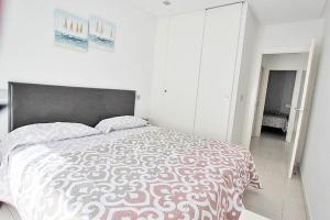 a bedroom with a large bed in a white room at Apartamento 10 Marjal Playa Centro de Guardamar in Guardamar del Segura +21 photos