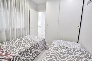 1 Schlafzimmer mit 2 Betten und einem Fenster in der Unterkunft Apartamento 10 Marjal Playa Centro de Guardamar in Guardamar del Segura