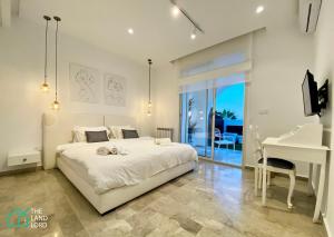 a bedroom with a white bed and a white desk at New 1 bd with garden and sea side at Marsa Cornich in Douar el Hafey