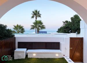 an archway over a white building with a view of the ocean at New 1 bd with garden and sea side at Marsa Cornich in Douar el Hafey