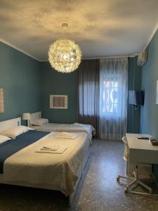 Un dormitorio con dos camas y una lámpara de araña. en Interno1 Bari Policlinico, en Bari