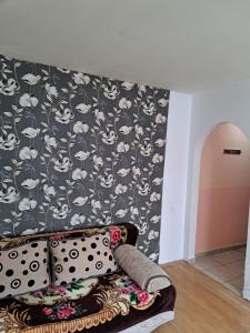 a couch in a room with a black and white wallpaper at Apartament Amurg in Dej