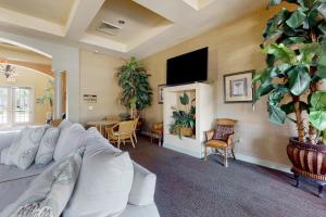 salon z białą kanapą i telewizorem w obiekcie Beach Sunflower, Unit #516 w mieście Fort Myers