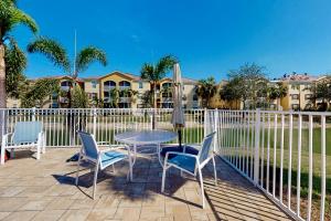 een patio met een tafel en stoelen en een hek bij Beach Sunflower, Unit #516 in Fort Myers