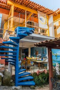 uma escada azul que leva a uma casa com um barco em Pousada Casa do Rio Hostel - 8 min do Centro Hístorico - Passeio de Barco com saída da Pousada -Pago a parte- Perto das Praias e Beira Rio em Paraty
