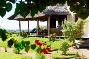 ein Resort mit einem Gebäude mit Grasdach in der Unterkunft Villa Moringa lodge 