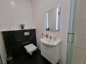 biała łazienka z umywalką i toaletą w obiekcie Villa Międzyzdroje w mieście Międzyzdroje