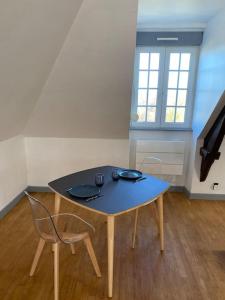 a table and a chair in a room at Studio un cocon à la campagne in Saint-Samson-sur-Rance