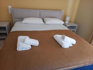 1 dormitorio con 1 cama con toallas en Hotel Prinos, en Himare