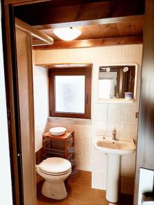 a small bathroom with a toilet and a sink at La casetta delle bambole. in Massello