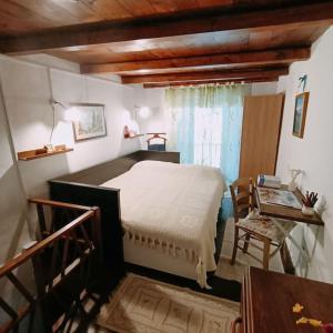 a bedroom with a bed and a chair and a window at La casetta delle bambole. in Massello