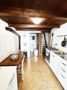 a kitchen with a table and a stove top oven at La casetta delle bambole. in Massello