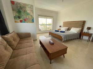 ein Wohnzimmer mit einem Bett und einem Sofa in der Unterkunft Villa des Oliviers Hammamet B&B in Hammamet