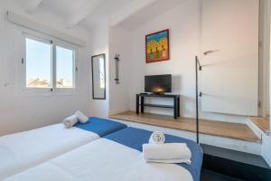 een witte kamer met een bed en een televisie bij Holiday Palma Apartments - TI in Palma de Mallorca