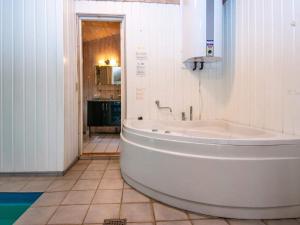 8 person holiday home in Oksb l في Oksbøl: حوض أبيض في حمام مع حوض