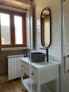 een badkamer met een wastafel en een spiegel bij Casa do Tio Plácido in Valezim