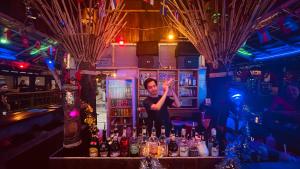 a man standing behind a bar with bottles of alcohol at Phi Phi Relax Beach Resort in Phi Phi Islands