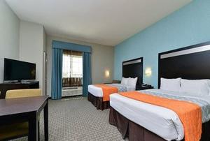 a hotel room with two beds and a flat screen tv at Suburban Studios Port Arthur in Port Arthur