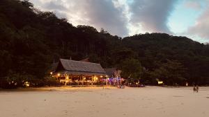 a building on the beach in front of a mountain at Phi Phi Relax Beach Resort in Phi Phi Islands