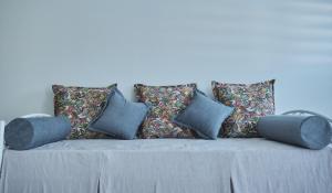 un sofá con almohadas en la sala de estar en BUTTERFLY SUITES by STELIOS en Keramotí