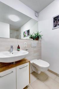a white bathroom with a toilet and a sink at Ferienwohnung Am Rehgarten in Ramsen