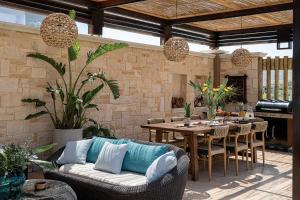 a patio with a couch and a table and chairs at Peacock Villa in Daratso