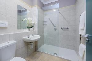 a bathroom with a shower and a toilet and a sink at Castlerosse Park Resort in Killarney