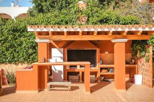 een buitenstructuur met een tafel en een patio bij Villa Rosada - Private pool & Barbecue in San Jose de sa Talaia