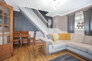 a living room with a couch and a table at Beautiful 4 Bedroom Cottage - Free Parking in Edinburgh