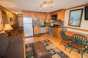 a kitchen and dining room with a table and a refrigerator at ML278 Mountaintop Retreat 2BR 2BA Lift Access Wifi in Snowshoe